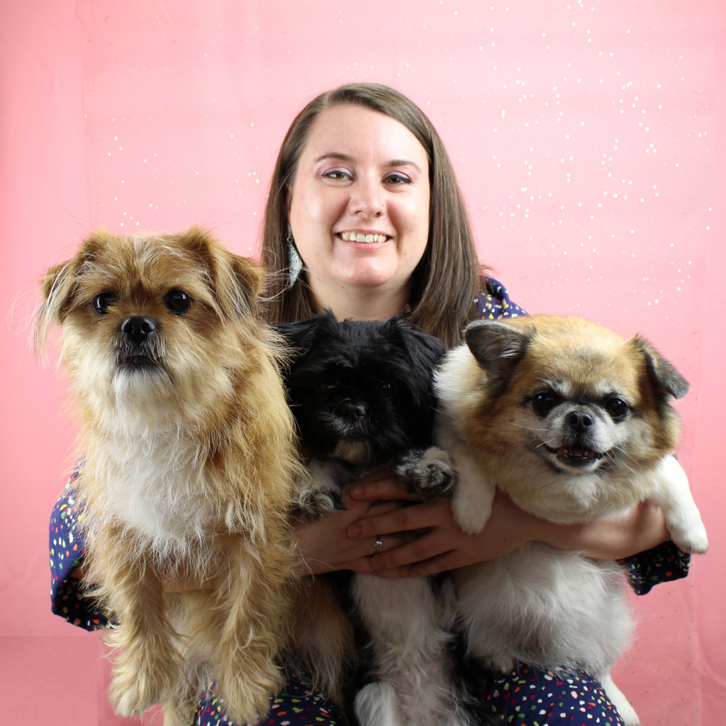 a woman holdin g 3 dogs