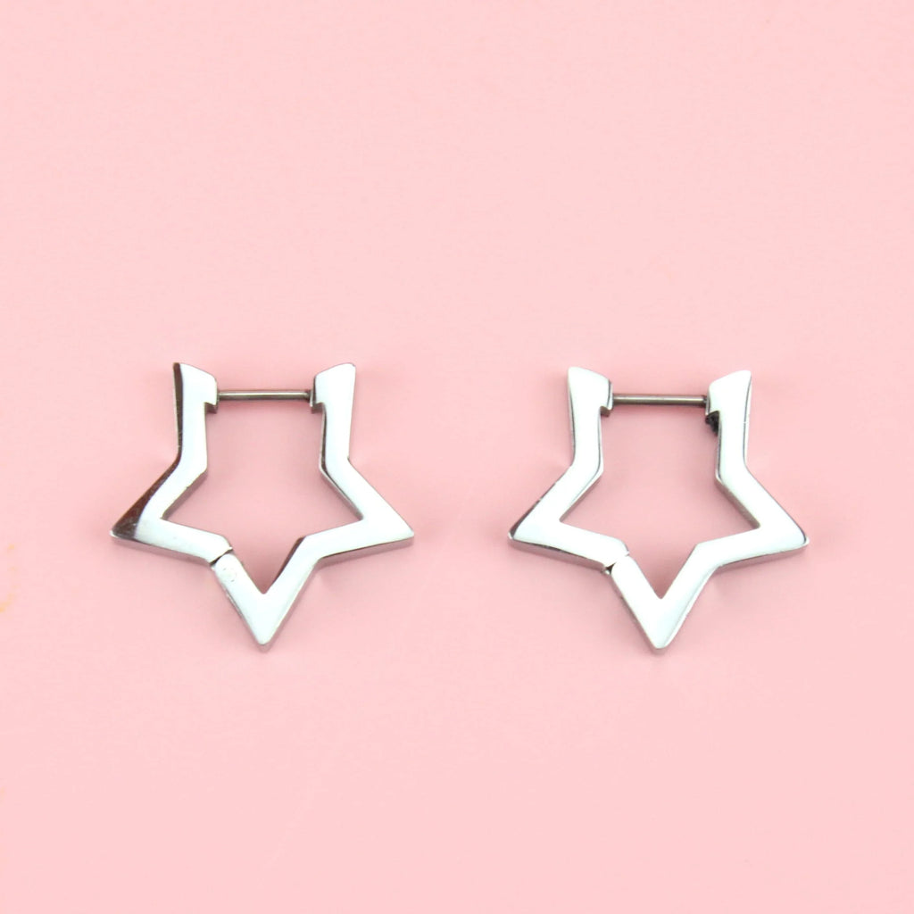 Star Huggie Earrings on a pink background