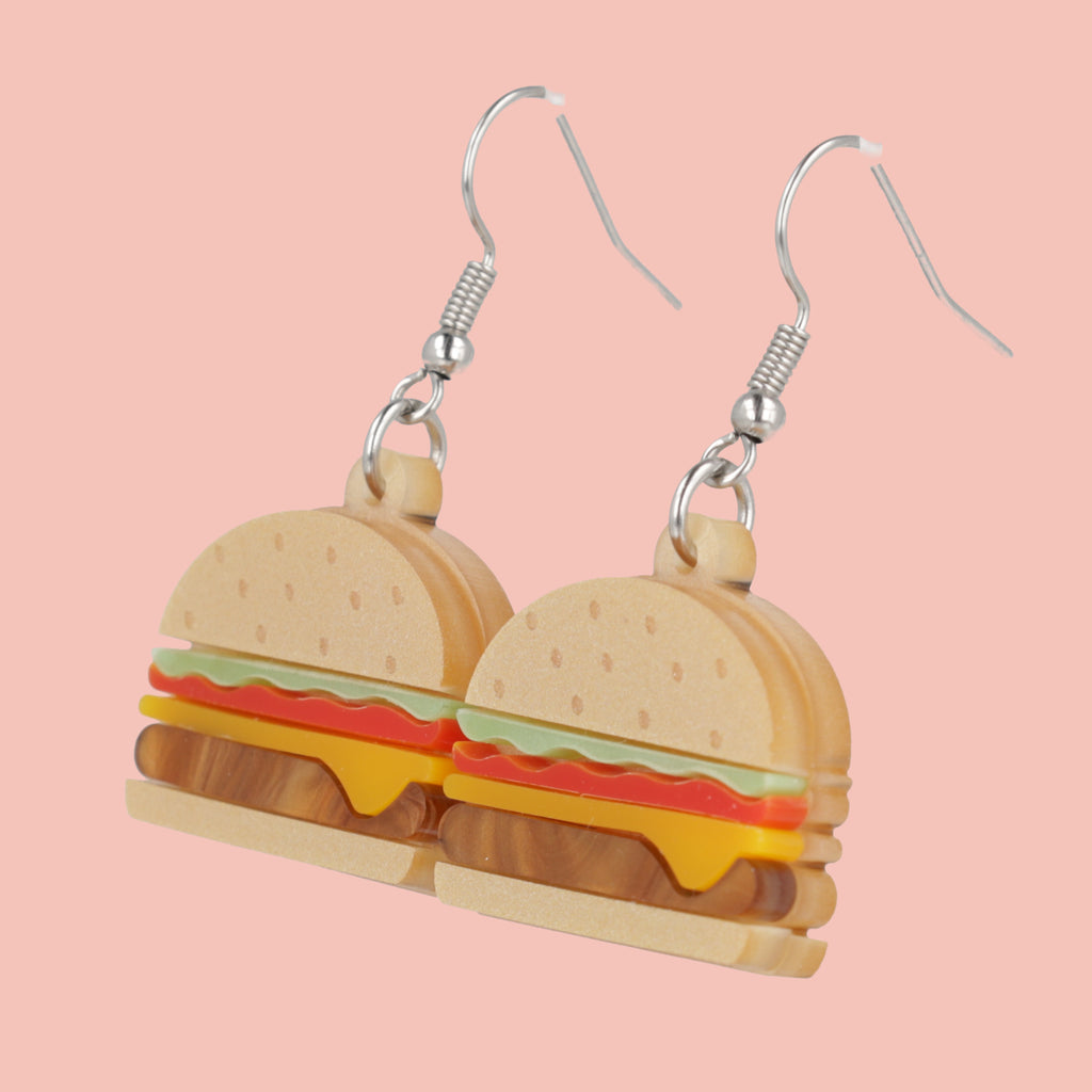 Cheeseburger acrylic charms featuring a beige bun and brown marble patty with lettuce and tomato with stainless steel earwires