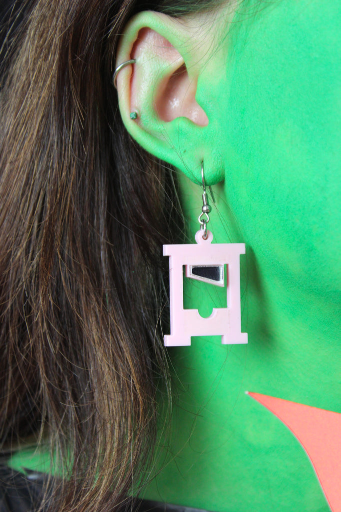 Model wearing Baby pink guillotine charms on stainless steel earwires