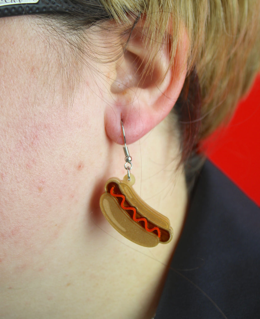 Model wearing ketchup hot dog earring on stainless steel earwires