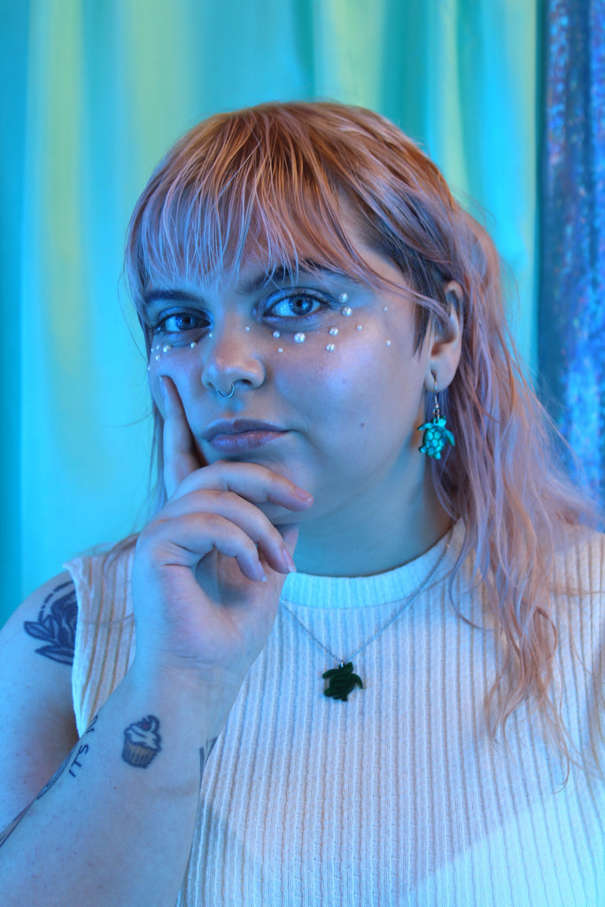 Model wearing Green marble turtle charms on stainless steel earwires