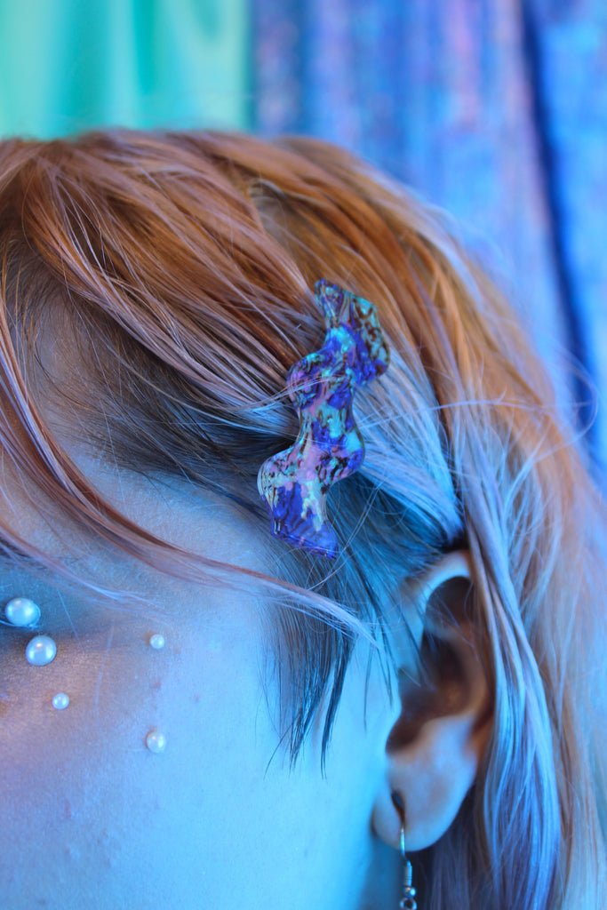 Model wearing Wavy alligator clips featuring a purple abalone design