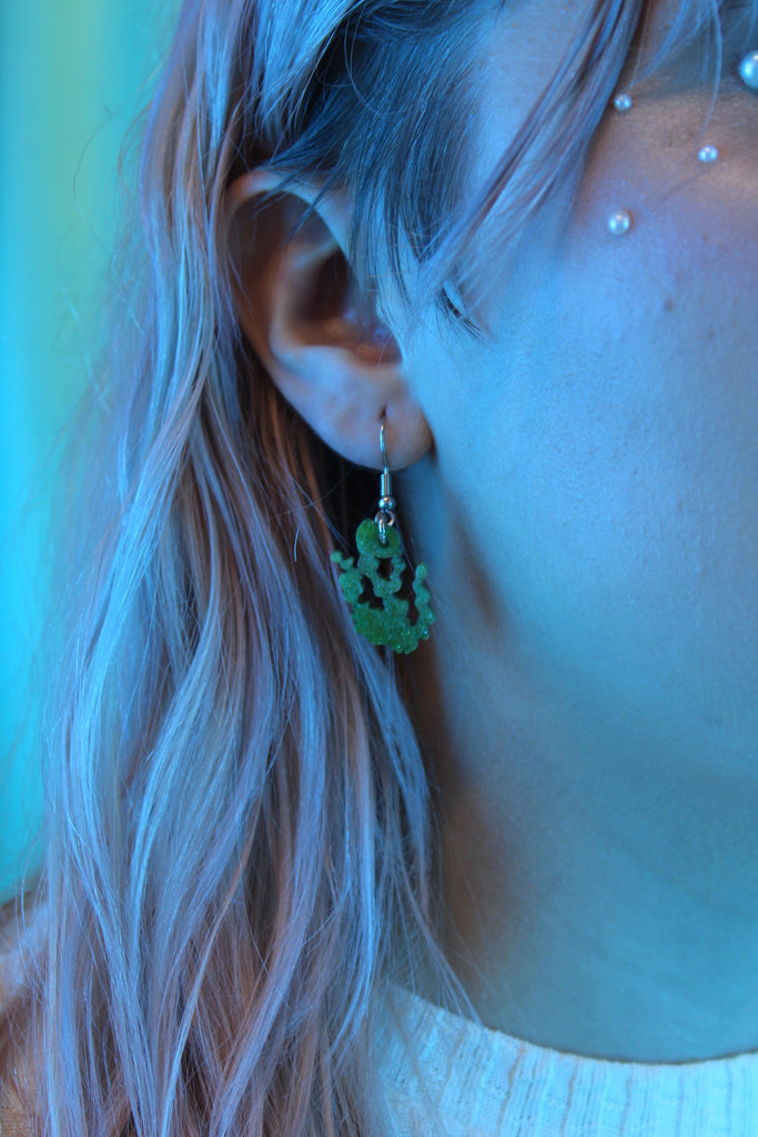 Model wearing Green glitter acrylic seaweed charms on stainless steel earwires