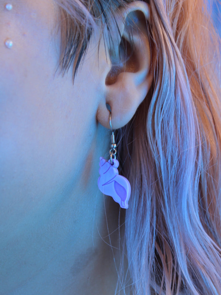 Model wearing Lilac hermit shell charm on stainless steel earwires