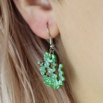 Model wearing Green glitter acrylic seaweed charms on stainless steel earwires