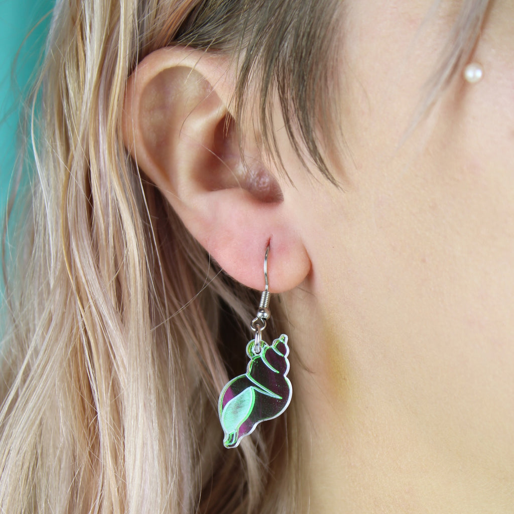 Model wearing Iridescent conch shell charms on stainless steel earwires