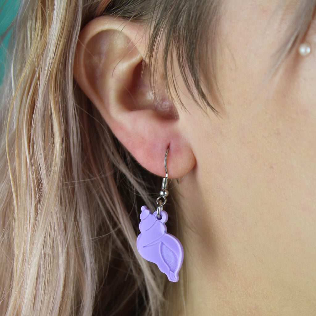 Model wearing Lilac hermit shell charm on stainless steel earwires