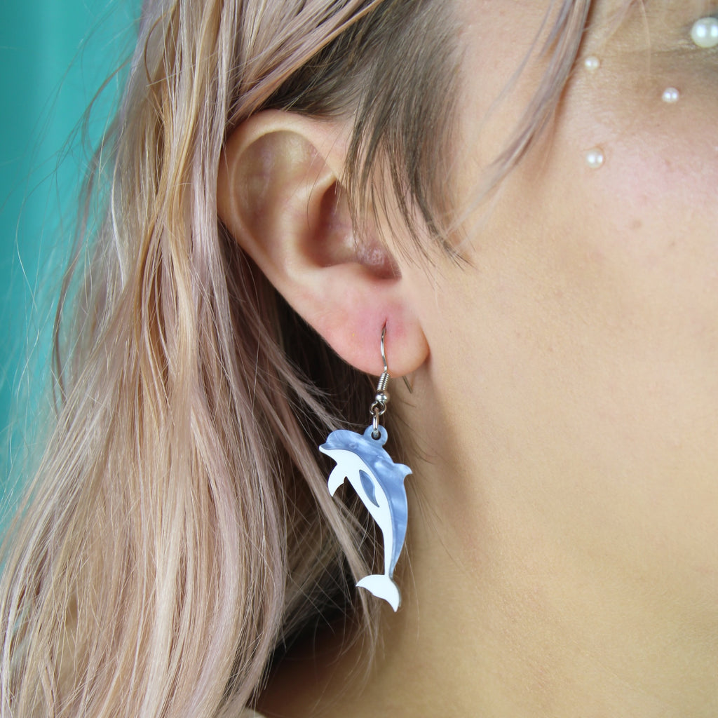 Model wearing Blue marble dolphin charms on stainless steel