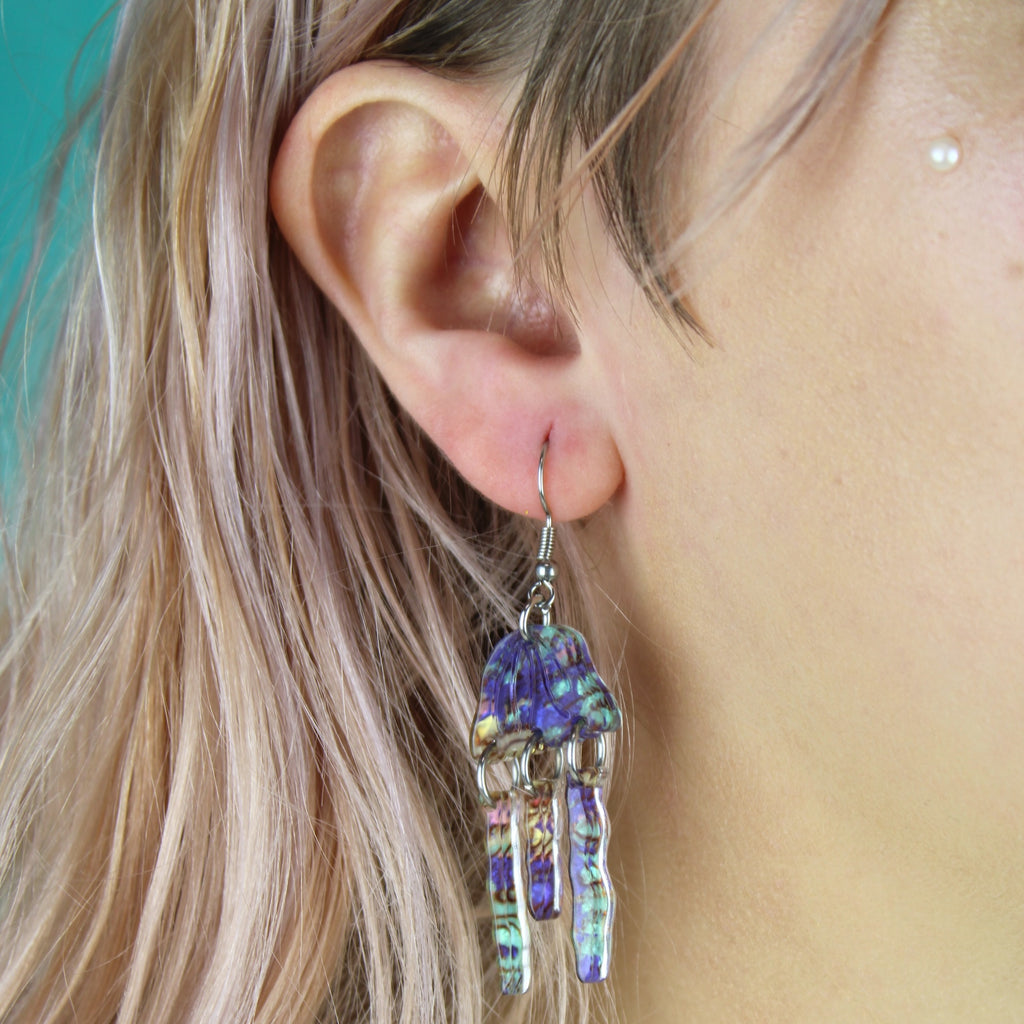 Model wearing Purple abalone acrylic jellyfish charms on stainless steel earwires