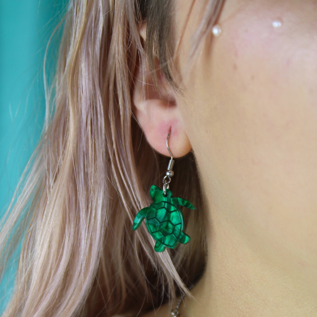 Model wearing Green marble turtle charms on stainless steel earwires