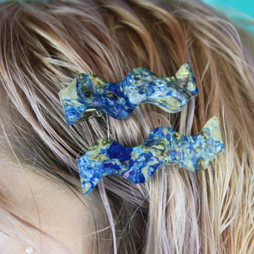 Model wearing Wavy alligator clips featuring a blue abalone design