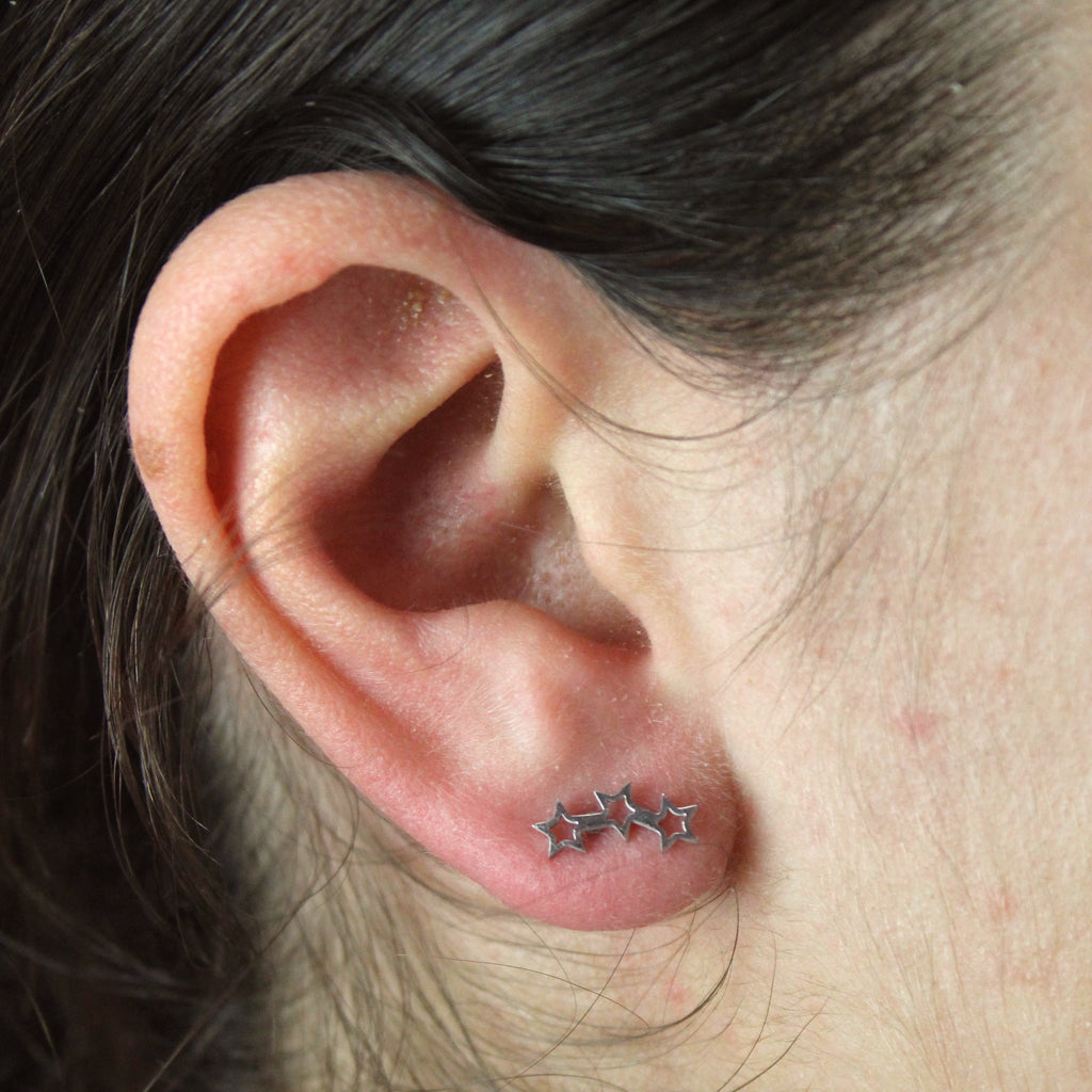 Ear wearing Stainless steel studs featuring a cut out triple star design