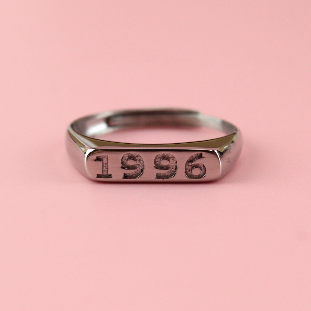 Stainless steel ring with 1996 engraved on the front