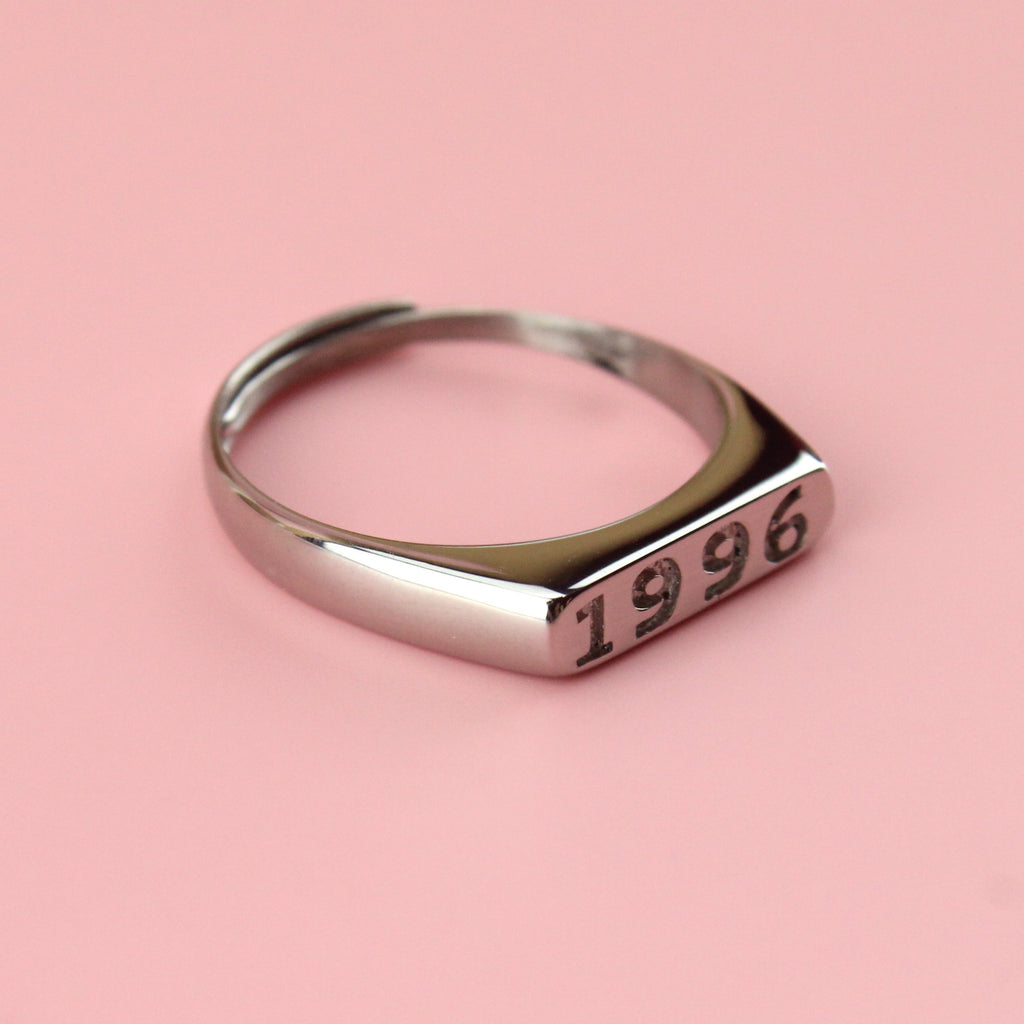 Stainless steel ring with 1996 engraved on the front