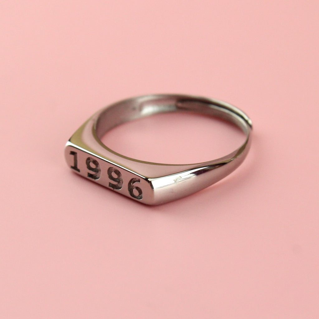 Stainless steel ring with 1996 engraved on the front