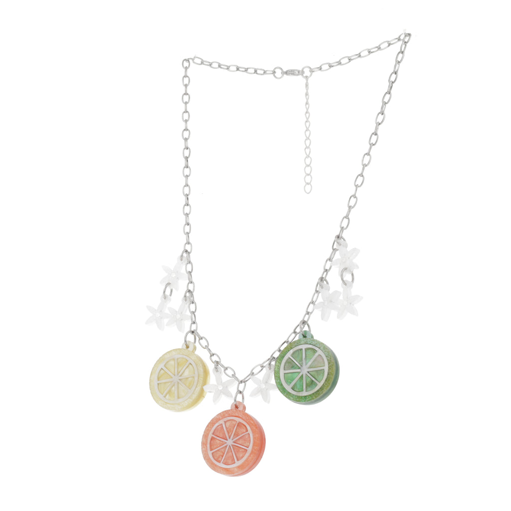 Model wearing necklace featuring lemon, orange and lime slice pendants and white flowers on an oval link stainless steel chain