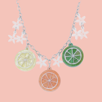 necklace featuring lemon, orange and lime slice pendants and white flowers on an oval link stainless steel chain