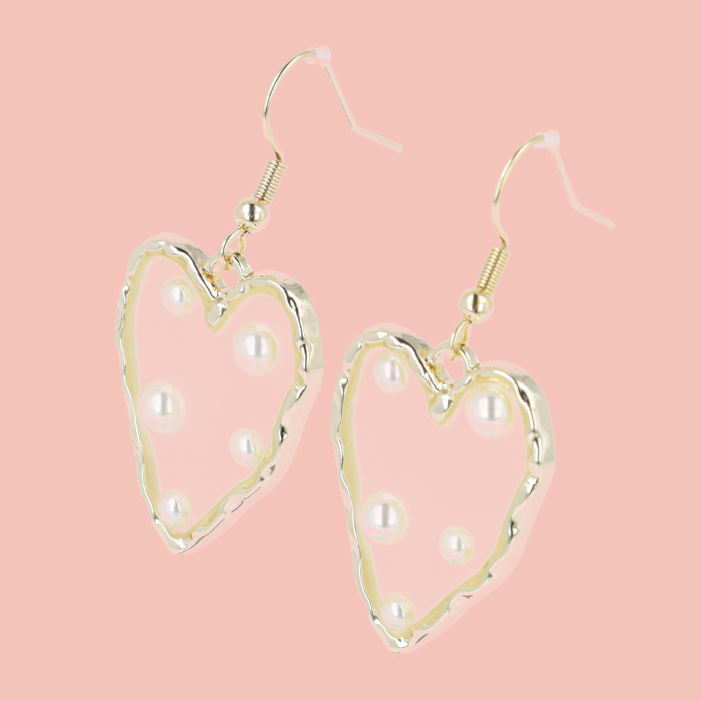  heart-shaped earrings featuring a stunning gold outline and a transparent middle filled with shimmering pearls