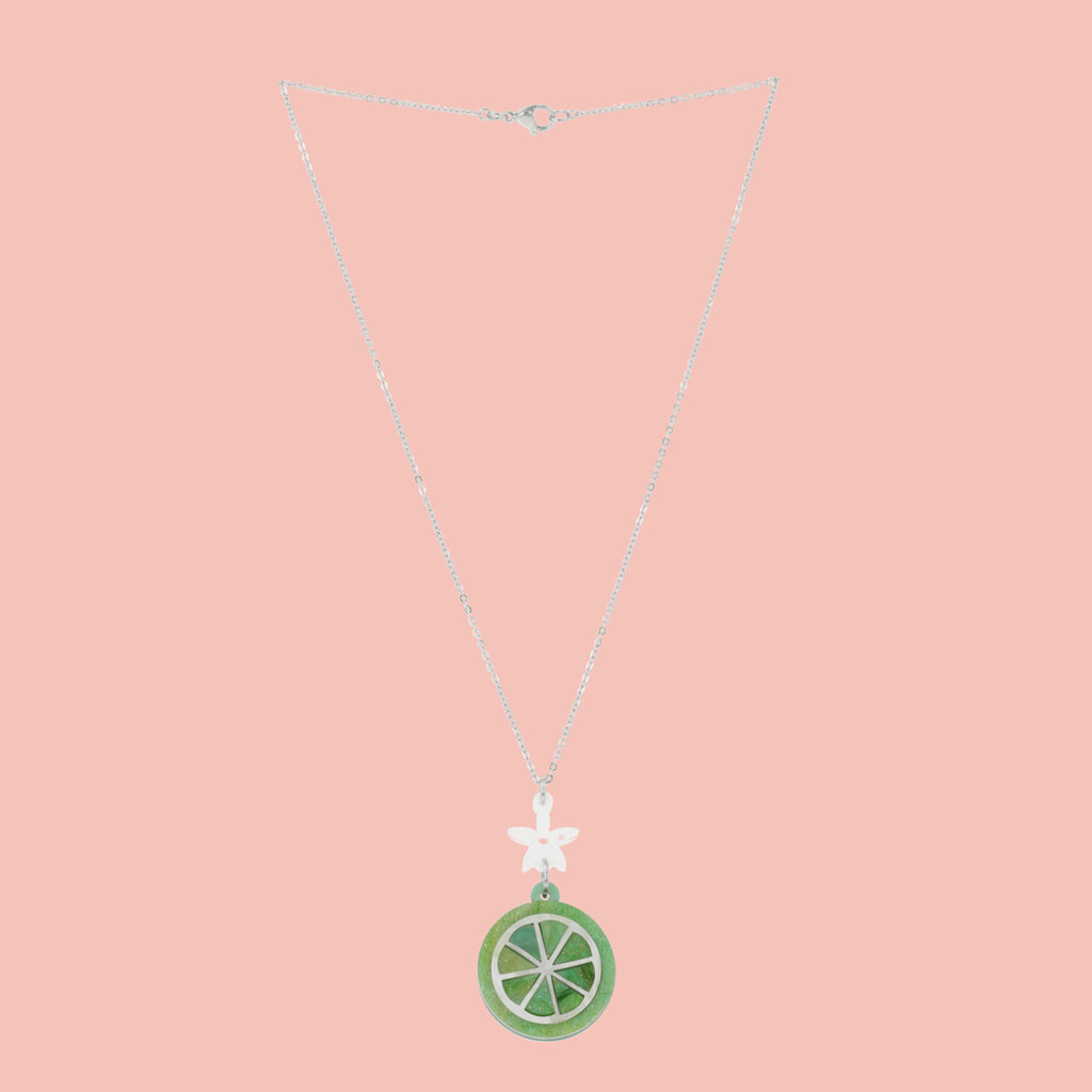 Lime slice pendant suspended rom a white flower and stainless steel chain