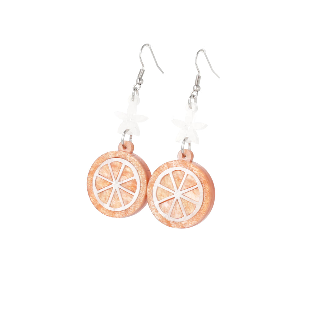 orange slice pendant suspended from white flower charms on stainless steel earwires