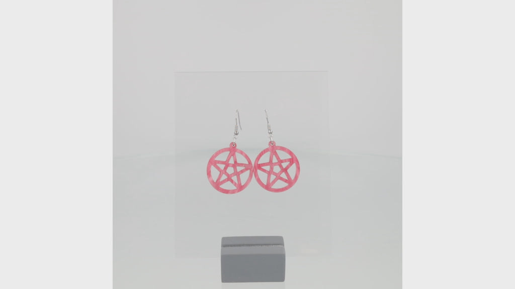 360 view of model wearing marble pink cut out pentacle charms on stainless steel earwires